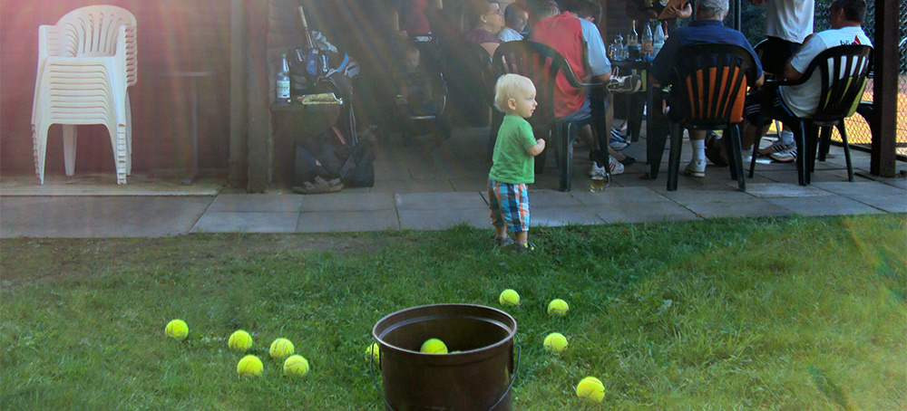 Kind mit Tennisbällen